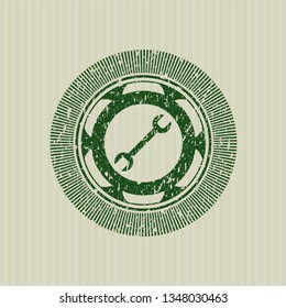 Green wrench icon inside distressed grunge style stamp