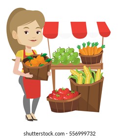 Greengrocer standing near stall with fruits and vegetables. Greengrocer standing near market stall. Greengrocer holding basket with fruits. Vector flat design illustration isolated on white background