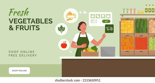 Greengrocer working in her shop, she is receiving orders online and she is prepraring fresh vegetables and fruits in a crate