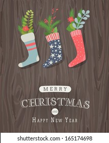 Greeting card, christmas stocking with nostalgic vintage decoration and pine branch over wooden background