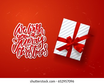  greeting card with gift box . Hand drawn calligraphy. concept handwritten we wish you a merry christmas