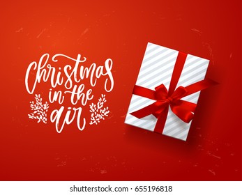  greeting card with gift box . Hand drawn calligraphy. concept handwritten Christmas in the air 