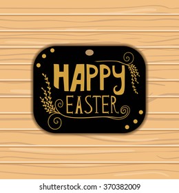 Greeting card with golden Happy Easter lettering  on wooden  background. 