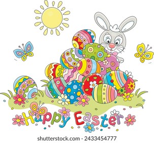 Greeting card with a happy Easter bunny and a pile of colorfully painted gift eggs on a pretty sunny lawn with spring flowers and merry butterflies fluttering around, vector cartoon illustration