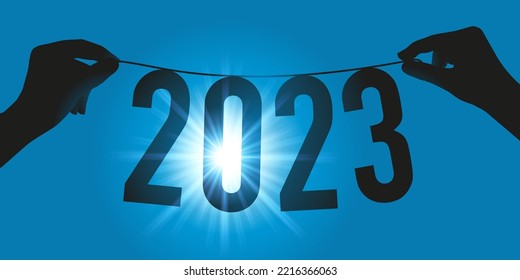 Greeting card representing hope and the future for the year 2023 with a garland on held by two hands, facing the rays of the sun.