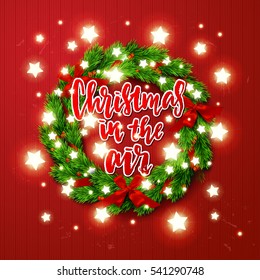 greeting card with wreath and Glowing star Lights. poster with a handwritten inscription. Brush Calligraphy "christmas in the air" 