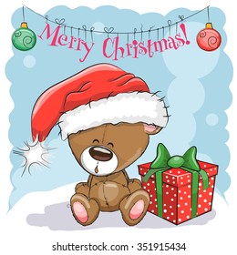 Greeting Christmas card Cute Teddy Bear in a Santa hat with gift
