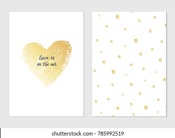 Greeting vector card for Valentine's Day. Gold brush drawn heart with text. Pattern with little gold glitter bubbles. Love is in the air lettering. Romantic vector  February 14 illustration.