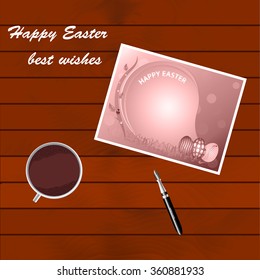 Greetings from the Holy Easter. Greeting card lying on a wooden table. A cup of coffee costs on a wooden table. Pen for writing greetings to the Holy Easter. Day of Resurrection of Jesus Christ.