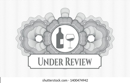 Grey abstract rosette with bottle and glass of wine icon and Under Review text inside