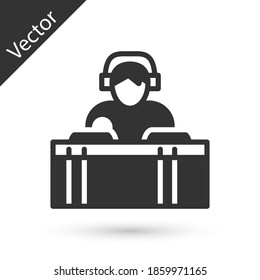 Grey DJ wearing headphones in front of record decks icon isolated on white background. DJ playing music. Vector.