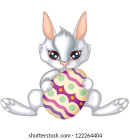 Grey-white cute easter bunny holding in its paws the painted egg