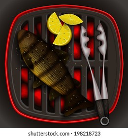 Grilled river trout with lemon on the grill and tongs for grilling. 
