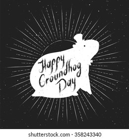 Groundhog Day greeting card. White design on a black background. Hand-written lettering on vintage grunge background. Groundhog Day emblem with the silhouette of a marmot in a retro style.