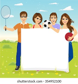 group of caucasian young students with different sports equipment holding a blank board woth copyspace for text