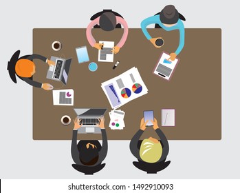 A group of five people are meeting on a table with many documents. Top view picture