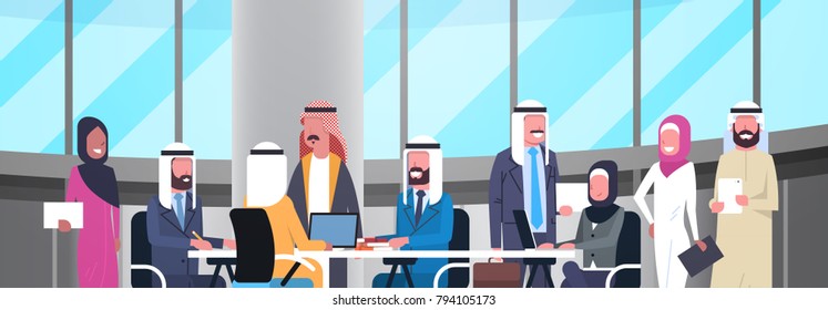 Group Of Happy Smiling Arabic Business People Working Together In Office Sit At Desk Muslim Workers Team Brainstorming Meeting Flat Vector Illustration