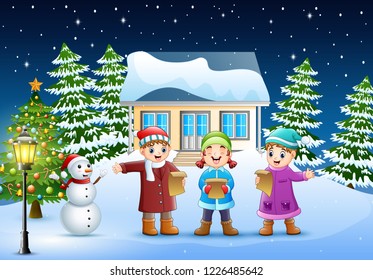 Group of kids in winter clotes singing christmas carols in the snowy village