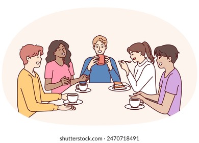 Group of multiethnic colleagues drink coffee sitting at table during break and laugh telling funny jokes. Happy people in casual wear relaxing enjoying socializing and meeting with school friends