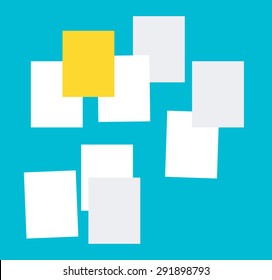 Group of papers on the blue wall with one important yellow paper on the top.