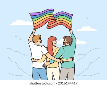 Group of people with LGBT flag travel with pride community and admire beautiful nature. Two man and woman hugging holding lgbt banner calling to be more tolerant towards lesbians or transgenders