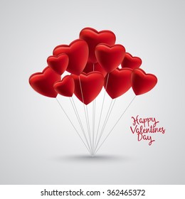 Group of red satin balloon hearts on strings with happy valentines day text on the side. Gray background and shadow.