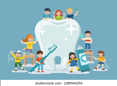 Group of smiling boys and girls standing next to big white tooth holding toothbrush showing healthy clean tooth encouraging teeth hygiene and care.