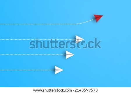 Group of white paper planes in one direction and one red paper plane pointing in different way on blue background. Business for new ideas creativity and innovative solution concepts.