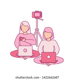 group of women seated using laptop computer with photographic camera
