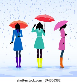 Group of women standing in the rain with umbrellas