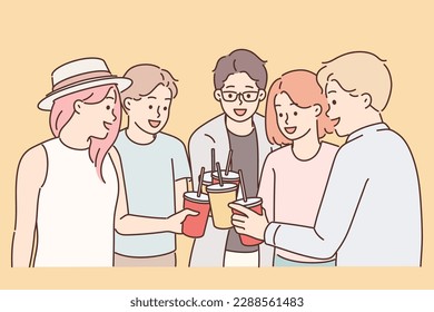 Group of young guys and girls drink drinks during holiday party from disposable cups with straw. Youth teenagers have good time together enjoying chatting with friends at holiday party