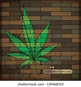Grunge background with cannabis leaf on brick wall