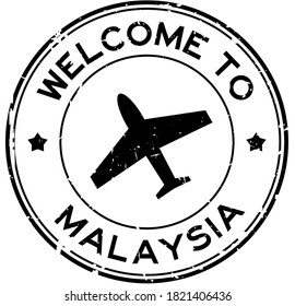 Grunge black welcome to Malaysia word with airplane icon round rubber seal stamp on white background