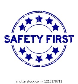 Grunge blue safety first wording with star icon round rubber seal stamp on white background