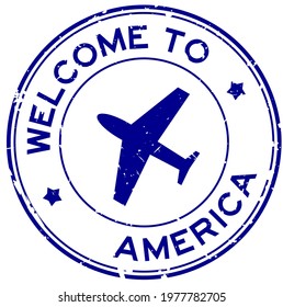 Grunge blue welcome to America word with airplane icon round rubber seal stamp on white background