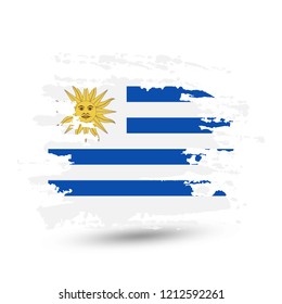 Grunge brush stroke with Uruguay national flag. Style watercolor drawing. Vector isolated on white background.