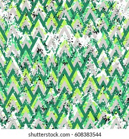 Grunge chevron vector pattern on splashed and splattered watercolor paint. Bold zigzag print with retro motif in vintage boho chic style. Modern geometric texture in green colors