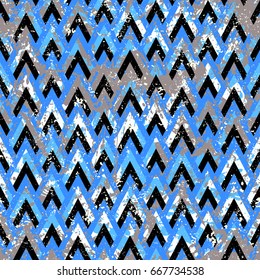 Grunge chevron vector pattern on splashed and splattered watercolor painted background. Bold zigzag print with retro motif in vintage boho chic style. Modern geometric chevron texture in blue colors