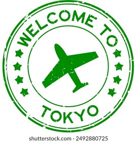 Grunge green welcome to tokyo word with plane icon round rubber seal stamp on white background