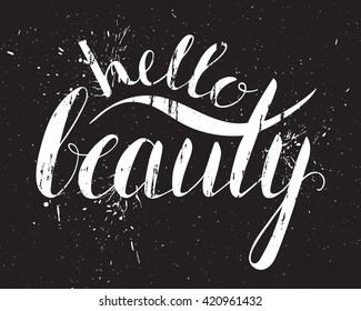 Grunge handwritten calligraphic ink inscription Hello beauty on black background with splatters. Hand write lettering for poster, postcard, t-shirt, greeting card, invitation. Vector illustration.