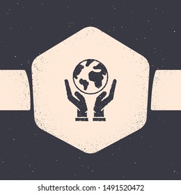 Grunge Human hands holding Earth globe icon isolated on grey background. Save earth concept. Monochrome vintage drawing. Vector Illustration