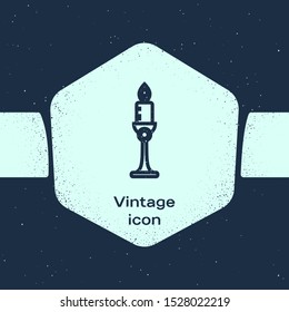 Grunge line Burning candle in candlestick icon isolated on blue background. Old fashioned lit candle. Cylindrical candle stick with burning flame. Monochrome vintage drawing. Vector Illustration