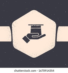 Grunge Magician hat in hand icon isolated on grey background. Magic trick. Mystery entertainment concept. Monochrome vintage drawing. Vector Illustration