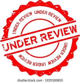 Grunge red under review word round rubber seal stamp on white background