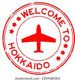 Grunge red welcome to hokkaido with airplane icon round rubber seal stamp on white background