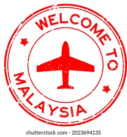 Grunge red welcome to Malaysia word with airplane icon round rubber seal stamp on white background