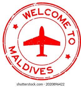 Grunge red welcome to Maldives word with airplane icon round rubber seal stamp on white background