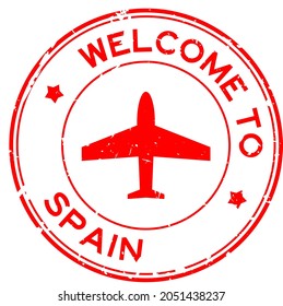Grunge red welcome to Spain word with airplane icon round rubber seal stamp on white background