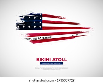 Grunge style brush painted Bikini Atoll country flag illustration with national day typography. Artistic watercolor brush flag vector