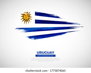 Grunge style brush painted Uruguay country flag illustration with Independence day typography. Artistic watercolor brush flag vector